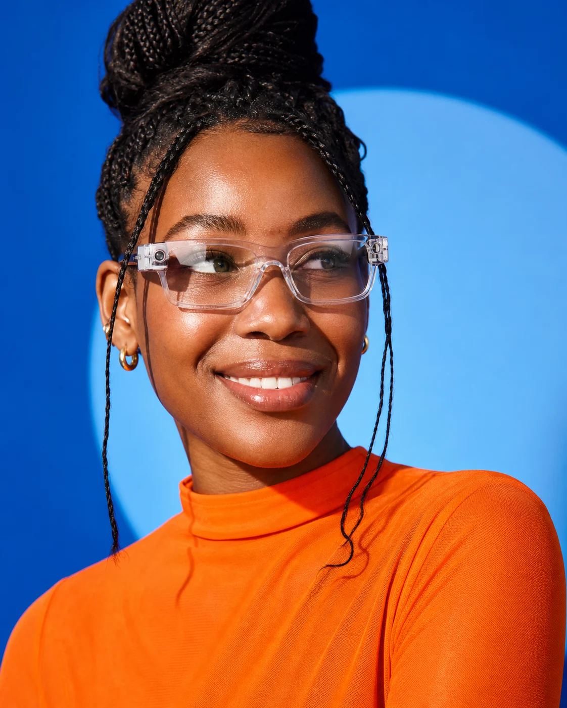 Woman wearing translucent smart glasses against a blue backdrop